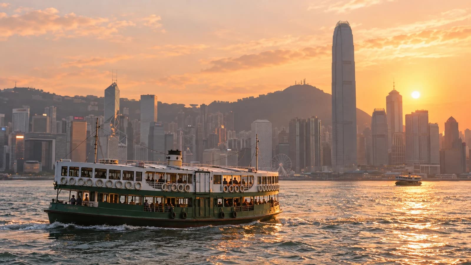 黃昏時維港海面上嘅渡輪，背景係港島海旁大廈